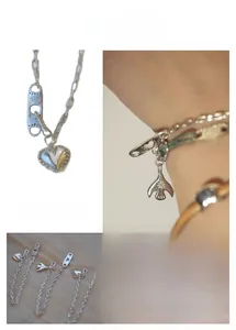 Détail de breloques cœur et oiseau en argent S925 sur un bracelet à maillons épais