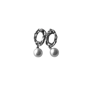 Macro detail of silver irregular hammered metal texture earrings with dangling white pearl