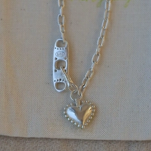 Vue détaillée du pendentif cœur en argent sterling 925 avec bordure perlée et chaîne