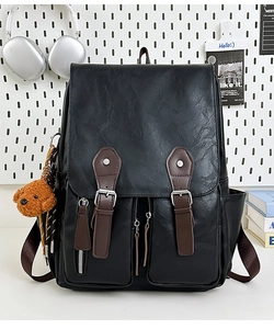 Detail eines schwarzen PU-Leder Rucksacks im Retro-Stil mit Taschen und Plüschanhänger