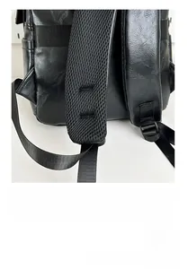 Detail of S-shaped ergonomic breathable mesh shoulder straps on black leather backpack