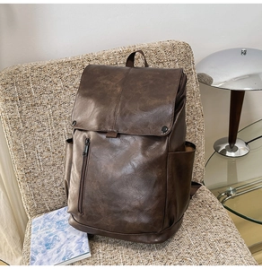 Detail of dark brown vintage PU leather backpack with magnetic buckles and side pockets