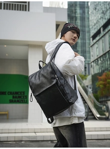 Detailed view of a black PU leather backpack in an urban setting with a modern style