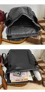 Detail showing the large interior capacity of this black minimalist faux leather backpack