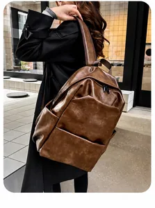 Close-up of vintage brown PU leather backpack with wide straps on city street