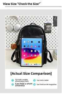 Detail view of large black leather backpack showing tablet capacity and teddy bear charm
