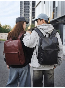 Lifestyle view of solid color PU leather backpacks in black and dark brown on street