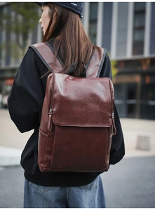Detail view of retro brown PU leather backpack for men with large flap and stylish texture