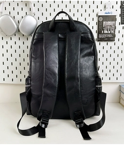 Detail of adjustable PU leather straps and side pocket on a minimalist black backpack