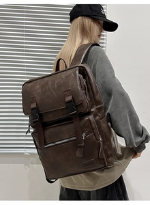 Détail d'un sac à dos vintage en cuir PU marron foncé avec poches à rabat et vue de profil