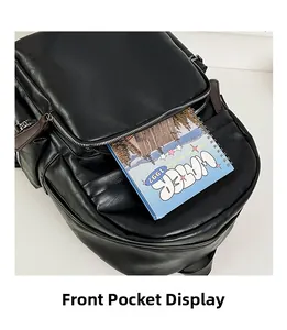 Detail showing the front zipper pocket and spacious interior of the black leather backpack