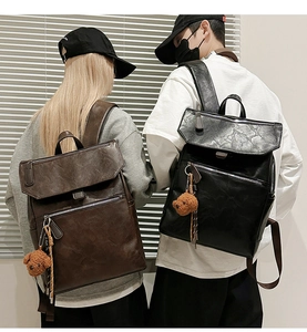 Close-up of vintage PU leather backpacks in black and brown with cute bear charms
