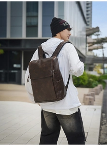 Detail view of brown vintage leather backpack showing retro texture and flap design