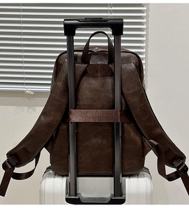 Détail du sac à dos vintage marron foncé avec sangle pour poignée de valise trolley