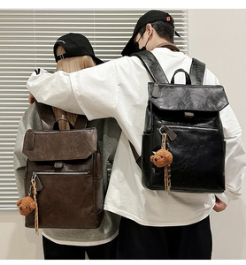 Detail of vintage PU leather backpacks with plush bear charms in brown and black