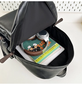 Detail view of high capacity black PU leather backpack showing main pocket interior