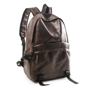 Detail view of dark brown faux leather backpack with metallic buckle and wide shoulder straps