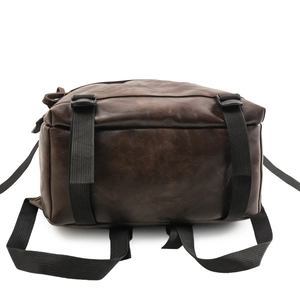 Detail view showing durable reinforced bottom and nylon straps of the brown leather backpack