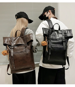 Detail of roll-top PU leather backpacks in brown and black with plush bear decor