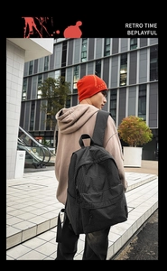 Outdoor street style shot of the classic black and grey plaid nylon backpack for women
