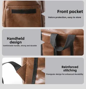 Detail view of brown leather bag with velcro pocket, handle and reinforced stitching