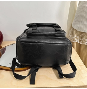 Detailed close-up of the black leather backpack base and nylon straps with buckles