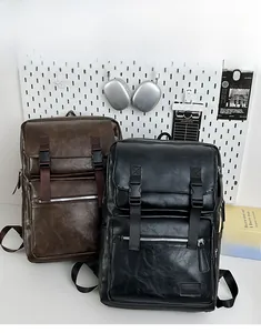 Gros plan sur les sacs à dos vintage en cuir noir et marron avec sangles réglables