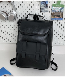 Detail view of black PU leather backpack with magnetic buckle pockets and side cup holder
