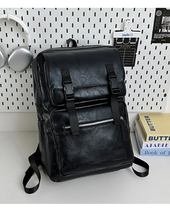 Detalle de mochila de cuero negro con hebillas ajustables y logotipo grabado elegante