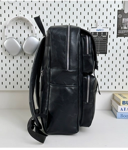 Primer plano de mochila de cuero PU negro con múltiples cremalleras metálicas y bolsillos