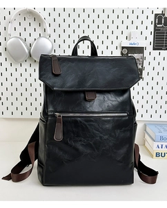 Close-up of black synthetic leather backpack featuring lychee texture and brown zipper pullers