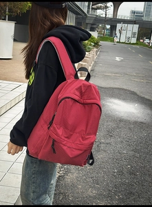 Detailed side view of a red and white checkered backpack in casual college style