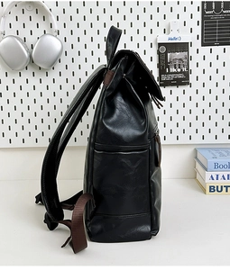 Side view of black leather backpack featuring brown straps and metal zipper detail
