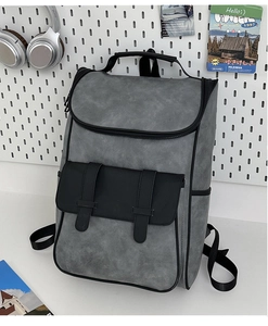 Detail of dark grey retro backpack with contrasting black flap and matte textured finish