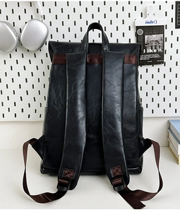 Detail of black leather backpack back panel with lychee grain and brown nylon straps
