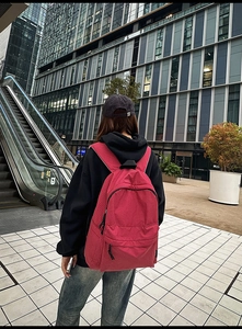 Detail of red checkered nylon backpack with front zipper pocket and durable straps