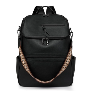 Detail of black faux leather backpack featuring a vibrant ethnic woven shoulder strap