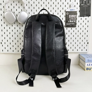 Minimalist black PU leather backpack back view with wide straps on white pegboard background