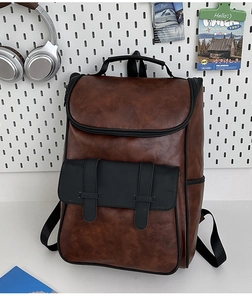 Detailed view of the vintage brown and black PU leather backpack with buckle front pocket