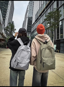 Outdoor shot of stylish checkered nylon backpacks in gray and olive green for urban travel