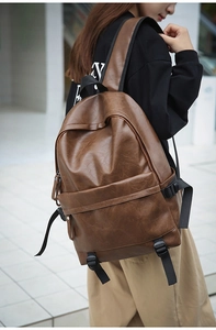 Detail of vintage brown leather backpack with lychee texture and large front pocket