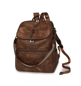 Detail of vintage brown leather backpack with woven ethnic strap and side pockets