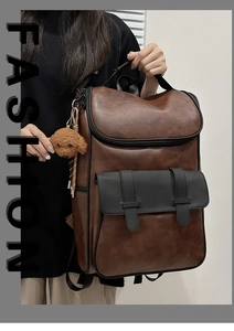 Detail view of brown PU leather backpack with black front flap and plush dog charm