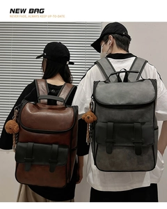 Detail view of large PU leather vintage backpacks in coffee and grey with fuzzy bear charm