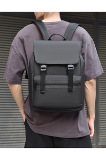 Detail of matte black waterproof backpack with flap closure and buckle on a male model