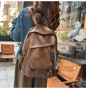 Detail of vintage brown leather backpack with cute puppy and chocolate charms