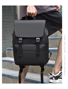 Street style black matte backpack shown in urban setting with buckle flap detail