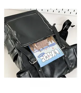 Close-up of black faux leather backpack front pocket showing interior storage capacity
