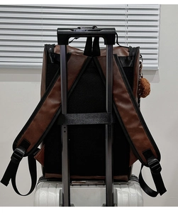 Dark brown PU leather backpack detail showing the luggage strap for easy travel use