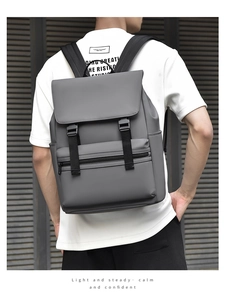 Gray business backpack with water-resistant fabric and buckle closure shown on model back